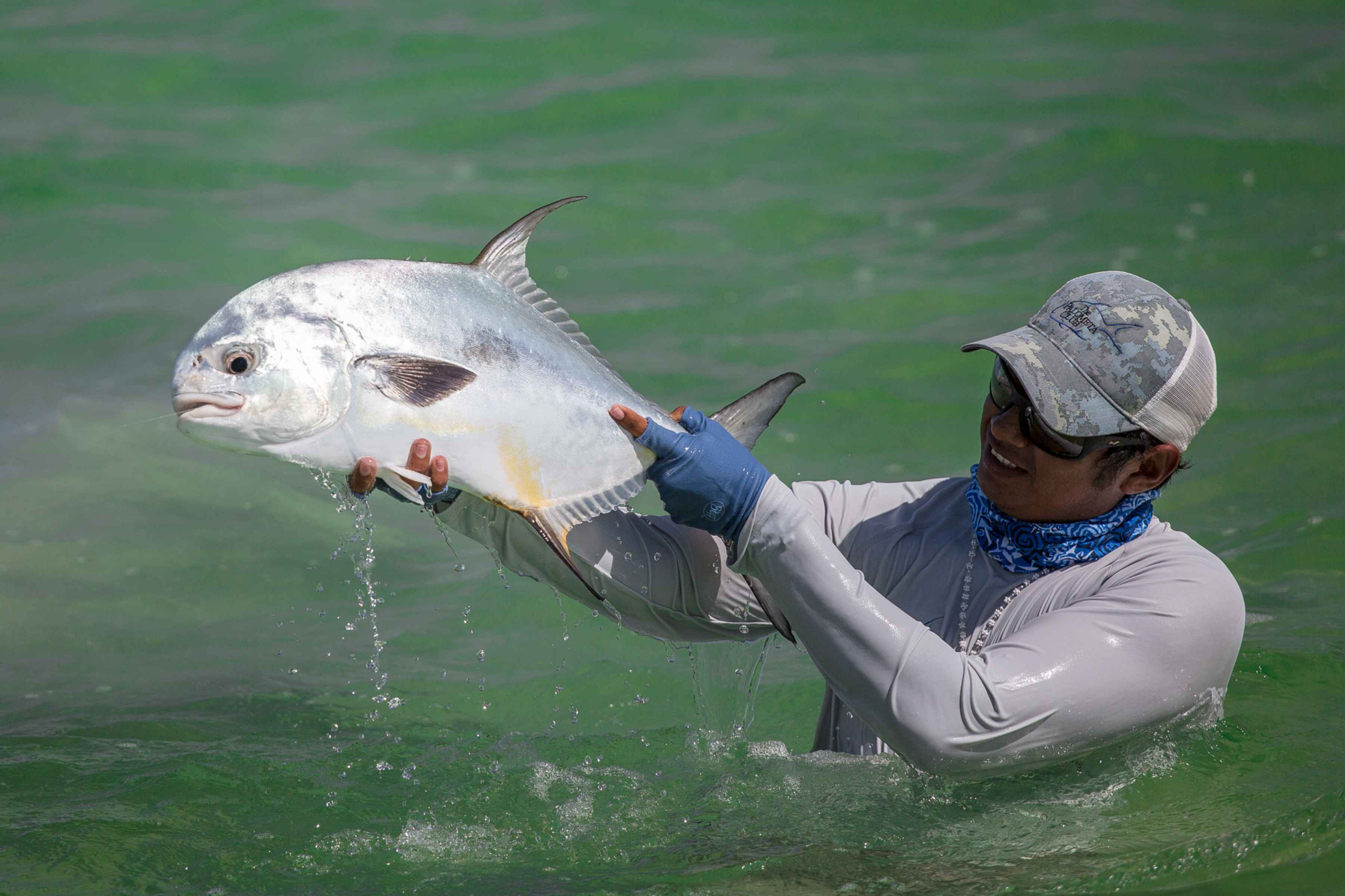 Tony hoists the first flats permit of the week in celebration. The hex is broken. Onward and upward (photo: Chad Shmukler). Permit - Palometa Club - Ascension Bay, Mexico